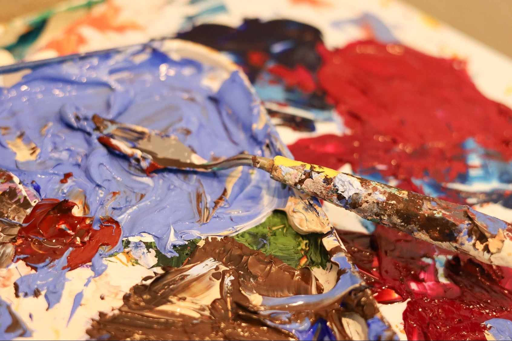 Artistic paint palette with various colors and a spoon