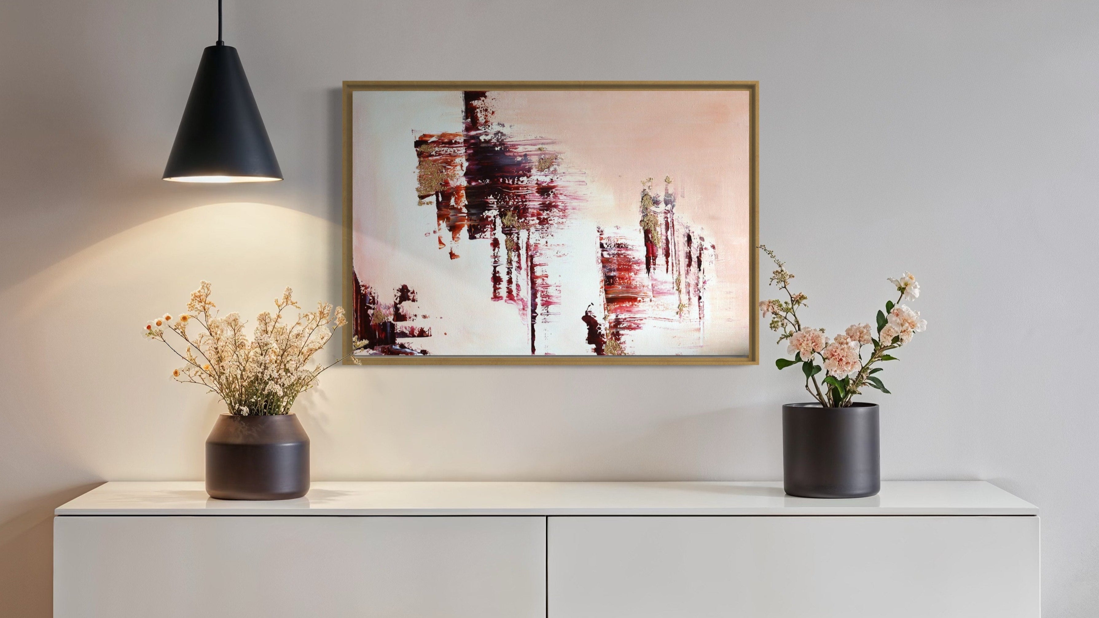 Modern interior with a white cabinet, abstract painting, and decorative plants.